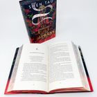 "THE BALLAD OF LOVE AND POISON", Buchcover mit roten Blumen, goldenem Text. Geöffnetes Buch zeigt Seiten 286-287.