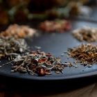 Verschiedene Gewürzhaufen auf einem dunklen Teller in einem sanften Licht platziert.