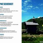 Texte: "ALPINE SICHERHEIT", "Alpine Notruf: 140", "Hör- oder sichtbares Zeichen". Rechts, kleine Holzkirche in Berglandschaft.