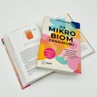 Buchcover: "DIE MIKROBIOM ERNÄHRUNG", buntes Design, offenes Buch daneben mit Bild eines Glases.