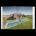 Moderne Villa mit Pool, gebaut aus Ziegeln, mit großem Garten und weiten Feldern im Hintergrund.