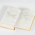 Ein aufgeschlagenes Buch mit einer Weltkarte, gelbem Einband, auf weißem Hintergrund.