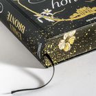 Ein Buchrücken mit "EMILY BRONTE" und "ANACONDA". Außen sind goldene Punkte und Schmetterlinge auf schwarzem Hintergrund.