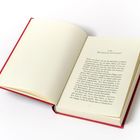 Text: Kapitelüberschrift "EIN WEIHNACHTSGAST", fortlaufender Text.  
Beschreibung: Geöffnetes Buch mit rotem Einband, Seite 7 sichtbar.
