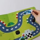 Rennstrecke mit Spielzeugautos und einem Motorrad auf einer bunten Rennstrecke, eine Hand hält ein blaues Auto.