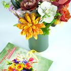 Buch mit dem Titel "Blütenpracht aus Papier". Papierblumen in Gelb, Weiß und Rot in einer grünen Vase.