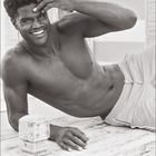 05, Kalendertage von 1 bis 31 im Mai markiert. Ein lächelnder, lässiger Mann liegt ohne Hemd auf einem Tisch. 