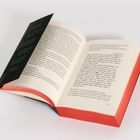 Offenes Buch mit schwarzem Einleger links. Text in deutscher Sprache auf cremefarbenen Seiten; Ränder in Rot.