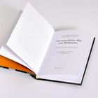"Ein menschlicher Weg zum Weltfrieden." Geöffnetes Buch mit orangem Vorsatzpapier.