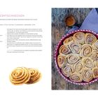 LUFTIGE ZIMTSCHNECKEN: Rezept für 16 Stück, Zutaten und Zubereitung. Runde Zimtschnecken in roter Form neben braunem Getränk.
