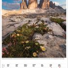 Kalenderseite Mai 2027 mit Bergpanorama der Drei Zinnen in den Dolomiten und blühenden Pflanzen im Vordergrund.