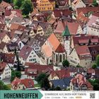 Hohenneuffen, Schwäbische Alb, Baden-Württemberg. Bild zeigt ein Dorf mit Fachwerkhäusern und einer Kirche mit grünem Dach.