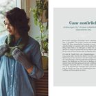 Ganz natürlich. Anleitungen für 1 Knäuel mitteldickes Garn. Frau in blauem Hemd, graue Handschuhe, grüner Schal vor Fenster.