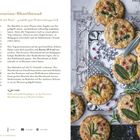 "Pecorino-Shortbread" Rezept. Goldene Kekse, dekoriert mit Kräutern und rosa Pfefferkörnern auf einem verzierten Untergrund.