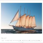 Mai 2027. Ein großes Segelschiff mit vollen Segeln fährt im Sonnenlicht auf offenem Meer.