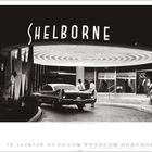 "Shelborne" in großen Buchstaben. Ein Auto vor einem beleuchteten Gebäude mit menschen in formeller Kleidung.