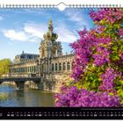 „Mai“ und „Kronentor am Zwinger“ sind sichtbar. Dekorative Architektur mit goldener Kuppel und blühendem Flieder im Vordergrund.