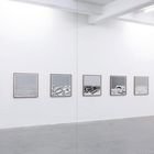 Zehn Schwarz-Weiß-Bilder mit geometrischen Mustern, gleichmäßig an einer Galeriewand arrangiert. Rechteckige Rahmen.