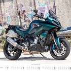 „MAI: Kalender mit einem grünen Motorrad vor einer Graffiti-Wand.“