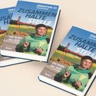 Drei Bücher mit dem Titel "ZUSAMMENHALTE STELLE" von SEBASTIAN 23. Darunter steht "Die Kraft des WIR".