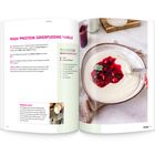 „High Protein Grießpudding Vanille“. Eine Schüssel Grießpudding mit rotem Frucht-Topping und Löffel, daneben ein Glas.