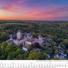 Schloss Burg und Burg an der Wupper, Mai 2027 Kalenderblatt, Abendstimmung über grüne bewaldete Hügel und historischen Schloss.