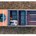 Texte: "LAND", "CHAPTER 03", "BUILD", "RUSTY".  
Draufsicht eines offenen Geländewagens auf trockenem Gras.