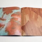 Keine Texte. Rechts: braune Holzmaserung. Links: abstraktes Muster in Rot, Türkis und Weiß.