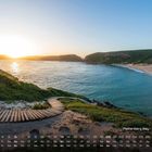 Text: "Plettenberg Bay - Südafrika 6" und Monatskalender. Sonnenuntergang über einer Küstenlandschaft mit Sandstrand.