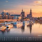 Kalender mit der Überschrift "Altstadt-Panorama". Vordergrund: Fluss mit Booten, Hintergrund: historische Gebäude bei Sonnenuntergang.