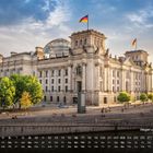 Regierungsbezirk 5. Kalender im Vordergrund, dahinter ein imposantes Gebäude mit gläserner Kuppel und deutscher Fahne.