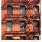 Kalenderblatt: Dezember 2027, Woche 49. Tage: 6-12. Ziegelgebäude mit Feuertreppen und Schattenmuster.