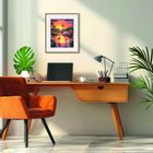 Ein Schreibtisch mit Laptop und Lampe, daneben ein oranger Stuhl. An der Wand ein Gemälde mit zwei Flamingos bei Sonnenuntergang.