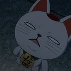 Ein liegender, weißer Katzentalisman mit geschlossenen Augen. Auf der Glocke steht ein japanisches Schriftzeichen.