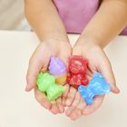 Eine Hand hält bunte Gummi-Figuren: ein roter Dinosaurier, ein blaues Elefant, ein grünes Känguru und ein gelbes Dessert.