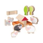 Holzfiguren, darunter Schafe, ein Hund, Bäume und ein kleines Haus mit rotem Dach. Verspielte, kindgerechte Gestaltung.