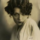 Der Text "Hartsook" erscheint, gezeigt wird eine Frau mit welligem Haar und ausdrucksstarken Augen in einem nostalgischen Stil.