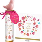 "Gute Wünsche zur Kommunion. Glück und Segen" sind mit Herzen und Blumen verziert. Ein rosafarbener Vogel krönt das Ganze.