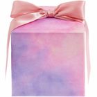 Eine schimmernde Geschenkbox in Rosa und Lila mit einer großen rosa Schleife.