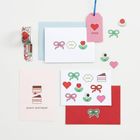 "XOXO" auf einem rosa Etikett. Geburtstagskarten mit Schleifen, Herzen und Blumen in bunten Farben.