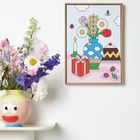 Ein helles, farbenfrohes Gemälde zeigt Blumen in einer Vase, eine Kerze, Geschenkbox und Kuchen. Links echte Blumen in Vase.