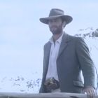 Keine Texte vorhanden. Ein Mann mit Hut und Anzug steht draußen und lächelt.