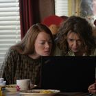 Zwei Frauen schauen konzentriert auf einen Laptop-Bildschirm, umgeben von Tassen und einer Flasche.