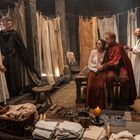 Es gibt keine sichtbaren Texte. Eine mittelalterliche Szene mit fünf Personen in einem Raum mit Holzwänden und Tüchern.