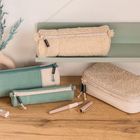 Text auf den Taschen: „smaepp“. Auf einem Holztisch liegen pastellfarbene Federmäppchen und Stifte. 