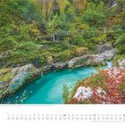 November. Fluss Soča, Tal, Triglav Nationalpark, Bovec, Slowenien. Türkisfarbenes Wasser, umgeben von Herbstlaub und Brücke.