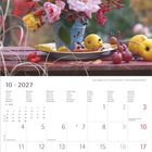 "10 · 2027" steht oben. Ein bunter Blumenstrauß mit Rosen und anderen Blumen steht auf einem Tisch im Freien. Darunter ist ein Kalender.