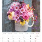 Oktober 2027. Kalender mit Blumenstrauß in Pastelltönen in einer gepunkteten Tasse. Texte für Tage in mehreren Sprachen.