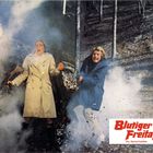 "Blutiger Freitag" in roter Schrift, mit dem Untertitel „Ein Gloria-Farbfilm“. Zwei Menschen stehen erschrocken im Wald. Rauch umgibt sie.