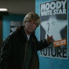Plakattext: "MOODY WHITE STAR FUTURE. OPENING CONCERT + TOUR NOV 27". Person zeigt auf das Plakat.